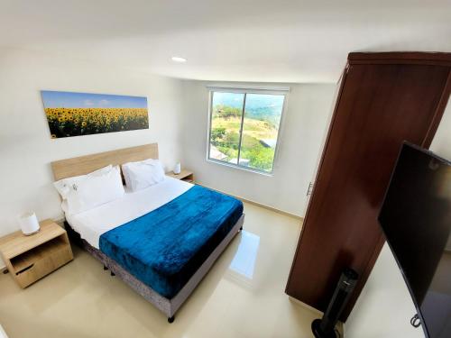 圣希尔Hermoso Apto - C.C San Gil Plaza的一间卧室设有一张床、一个窗口和一台电视