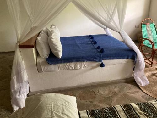 KisakiLemara Eco Camp的一间卧室配有一张带天蓬的床