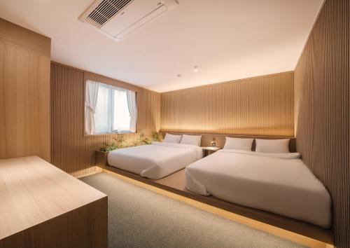 庆州UH Suite Gyeongju的一间卧室设有两张床和窗户。
