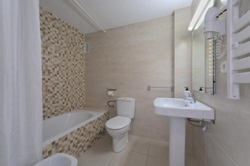 圣安东尼奥伊维萨全套房酒店公寓的浴室配有卫生间、盥洗盆和浴缸。