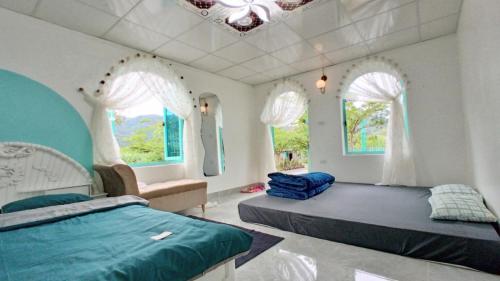 巴位Estrella Ba Vì Villas - Venuestay的一间卧室设有两张床、一张沙发和窗户。