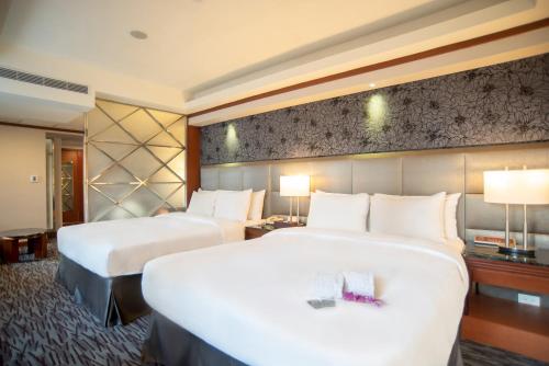 台中市鼎隆国际商旅的酒店客房设有两张床和两盏灯。