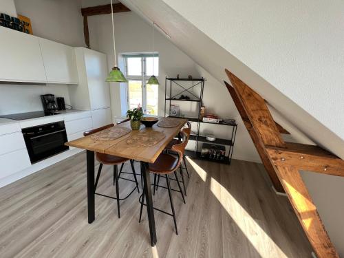 瓦尔德Hygge Loft的厨房配有木桌和一些椅子