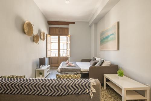 瓦伦西亚Macflats Valencia Puerto的客厅配有床和沙发