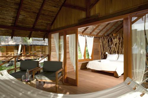 DorubaMetita Beach & Dive Resort的一间卧室配有一张床和吊床