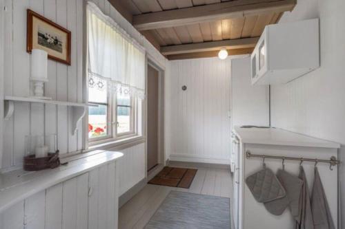 HemnesVeslestua - Beach Bliss & Fishing Fun的厨房设有白色的墙壁和窗户。
