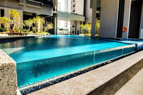 马六甲Attic Home Melaka Imperio Residence & Jonker的蓝色建筑中的游泳池