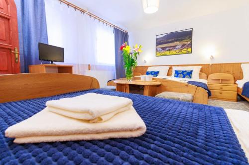 沙罗什保陶克Retel Vitez Vendégház的酒店客房带蓝色的床,带毛巾