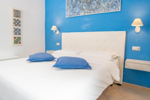 阿特拉尼Monastero Santa Rosalia的卧室配有白色床和蓝色的墙壁