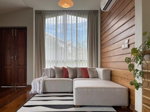 清莱Baan Jai Klang (บ้านใจกลาง)的带沙发和大窗户的客厅