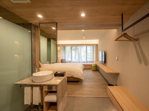 鹿谷乡溪头福华渡假饭店的一间带水槽的浴室和一张带镜子的床