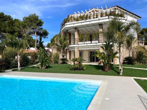 皮诺港Villa Aquamarina Pavoncella Rossa的一座房子前面设有游泳池