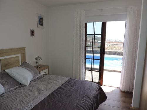 吉亚德伊索拉Arbinfo Casa Rural的一间卧室配有一张床,享有游泳池的景色