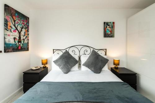 伦敦Luxury Islington Apartment with Balcony Islington的一间卧室配有一张带2个床头柜的大床