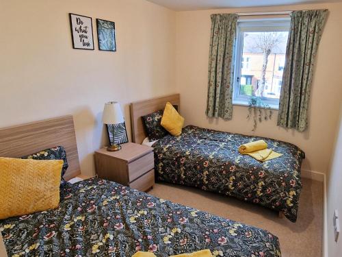 拉夫堡Luxury Spacious Apartment- Sleeps 4 Loughborough的一间卧室设有两张床和窗户。