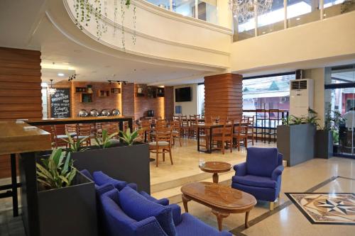 马尼拉奎松市马勒卡费萨尔酒店的大楼内一家带蓝色桌椅的餐厅