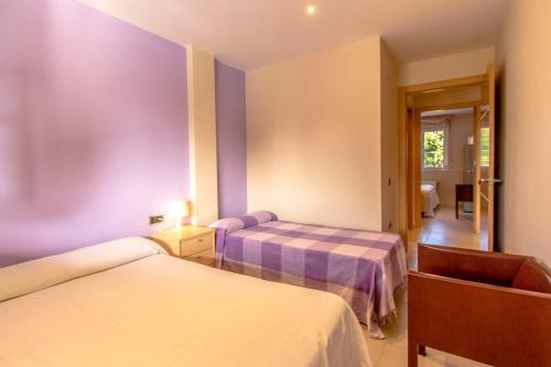 SilsCatalunya Casas Costa Brava Relax and Recharge 20km from beach!的紫色墙壁客房的两张床