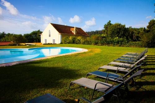 英雄港Quinta da Nasce Água的游泳池旁的一排草坪椅