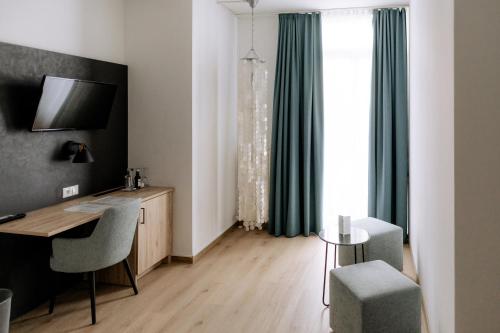多瑙河畔诺伊堡埃姆夫鲁斯酒店的客房设有书桌、椅子和窗户。
