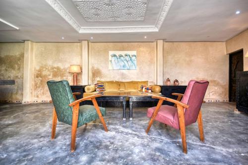 阿加迪尔Riad Amazine - Piscine - Rooftop - 6 or 7 Px的客厅配有桌子和两把椅子