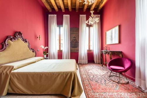 威尼斯Cà Regina Panada - passion on the Canal的红色的卧室设有一张床和粉红色的墙壁