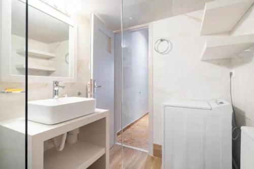 雅典Flisvos Marina refurbished apartment的白色的浴室设有水槽和镜子