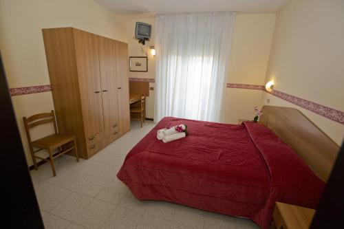 西尔米奥奈甘佛酒店的一间卧室配有红色的床和一张书桌