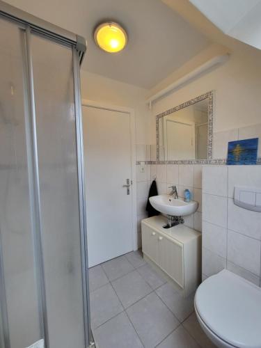 海德Westküste Ferienwohnung的带淋浴、盥洗盆和卫生间的浴室