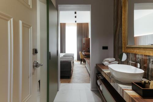 多布尔纳Hotel Švicarija - Terme Dobrna的浴室设有白色水槽和镜子