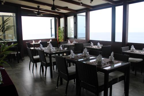 马累Beehive Premier的用餐室设有桌椅和窗户。