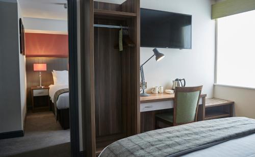 纽波特New Inn by Greene King Inns的酒店客房设有一间带书桌和床的卧室