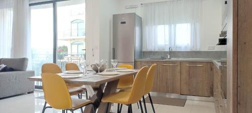 维多利亚Bright Stylish Apartment的厨房配有餐桌和黄色椅子