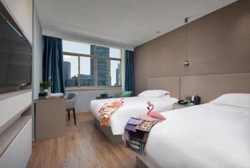 义乌Yiwu Manting Hotel International Trade City义乌漫庭酒店的酒店客房设有两张床和一台平面电视。