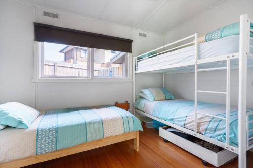 罗斯巴德Argo Sands的一间卧室设有两张双层床和一扇窗户。
