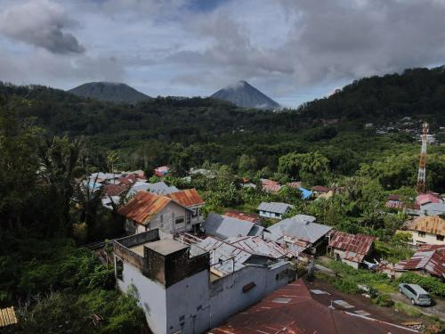 BajawaKristian Homestay的享有小镇的空中景色,以群山为背景