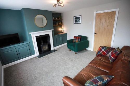 劳斯Auctioneers Cottage的带沙发和壁炉的客厅