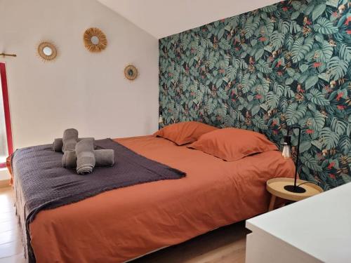 Saint-Dyé-sur-LoireGîte La Toue的一间卧室配有一张带热带壁纸的大型橙色床