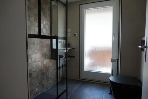 萨斯格伦德Rosenheim的浴室设有玻璃淋浴间和窗户。