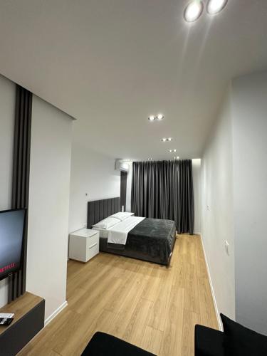 地拉那CozyStayApartments的一间卧室配有一张床和一台平面电视