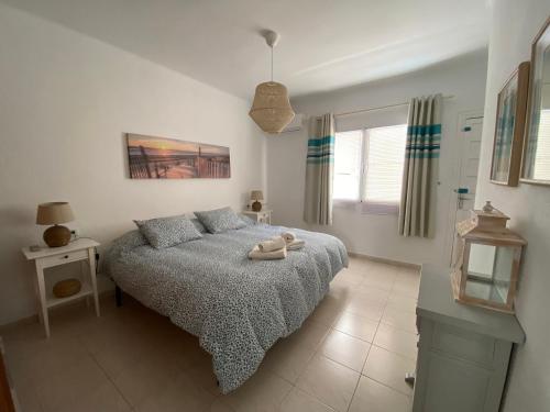内尔哈Casa del Mar 1的卧室配有床、桌子和窗户。