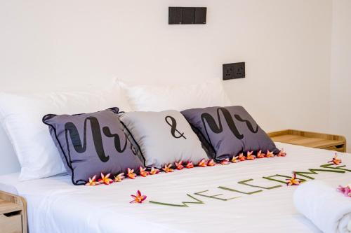 福拉杜岛Ahiva Village的一张带紫色和白色枕头的床,床上有鲜花