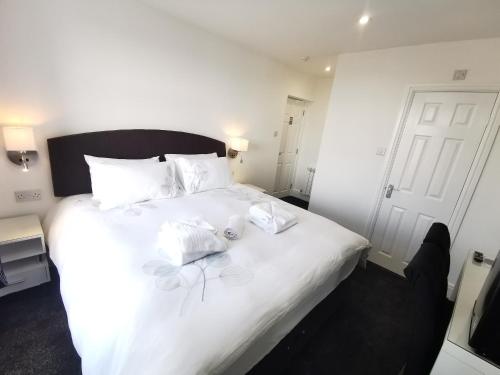莫克姆The Kerswell Hotel的卧室配有白色的床和2条毛巾