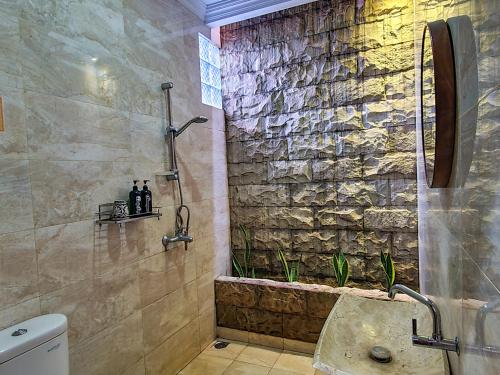 日惹纳尔姆苏月萨托诺旅馆的带淋浴的浴室和石墙
