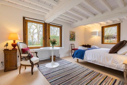 Biéville-en-AugeMaison "Le Pressoir" avec Grand Jardin的卧室配有一张床和一张桌子及椅子