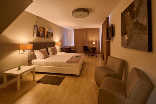 施马伦贝格Parkhotel Schmallenberg的酒店客房,配有床、沙发和椅子