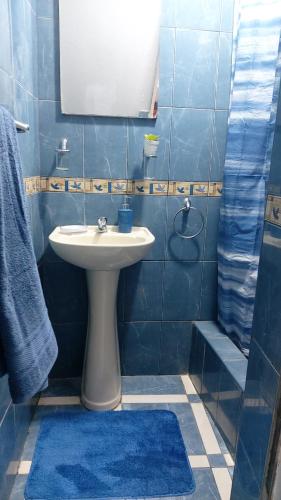 卡哈马卡Departamento en Cajamarca的蓝色瓷砖浴室设有水槽和镜子