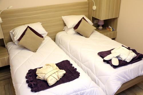 朱尼耶HOtello guest suites的两张位于酒店客房的床,配有毛巾