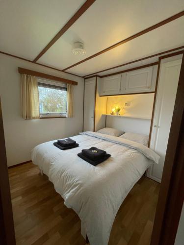 沃尔克姆Chalet D12 - Camping it Soal的卧室配有带毛巾的大型白色床