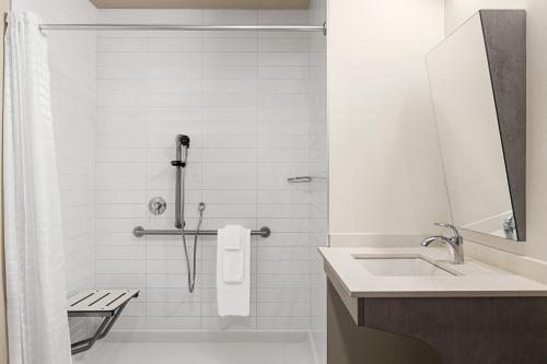 Sainte-Thérèse-de-BlainvilleMicrotel Inn & Suites by Wyndham Boisbriand的带淋浴和盥洗盆的白色浴室
