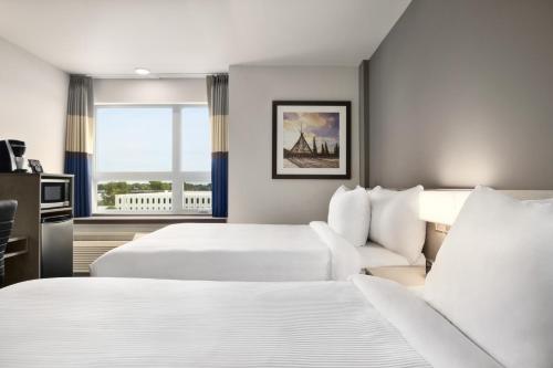 Sainte-Thérèse-de-BlainvilleMicrotel Inn & Suites by Wyndham Boisbriand的酒店客房设有两张床和窗户。